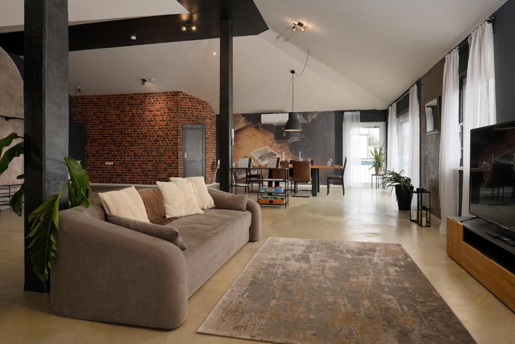 a living room with a couch and a television at Wohnkultur - Industrial Loft Schwetzingen in Schwetzingen