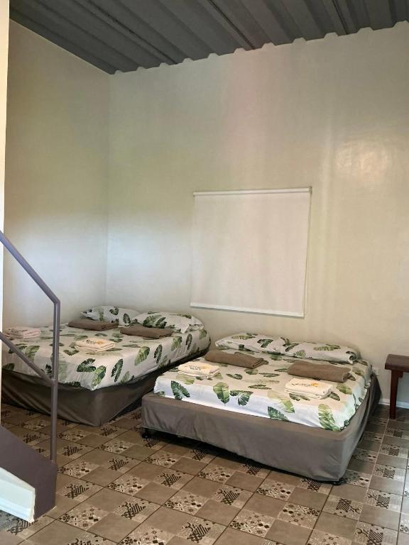 two beds sitting in a room with a wall at Serenity Busay Room 5 in Cebu City