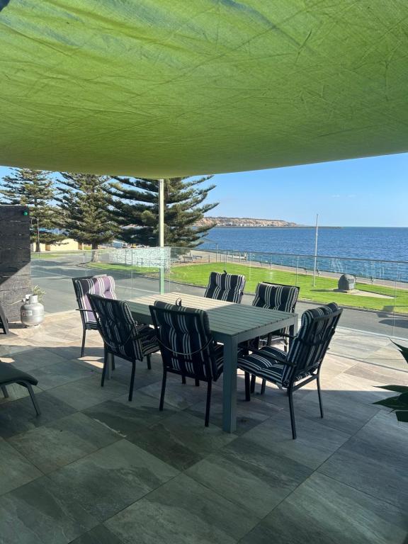 a table and chairs on a patio with the ocean at crystal blue apartment in Port Vincent