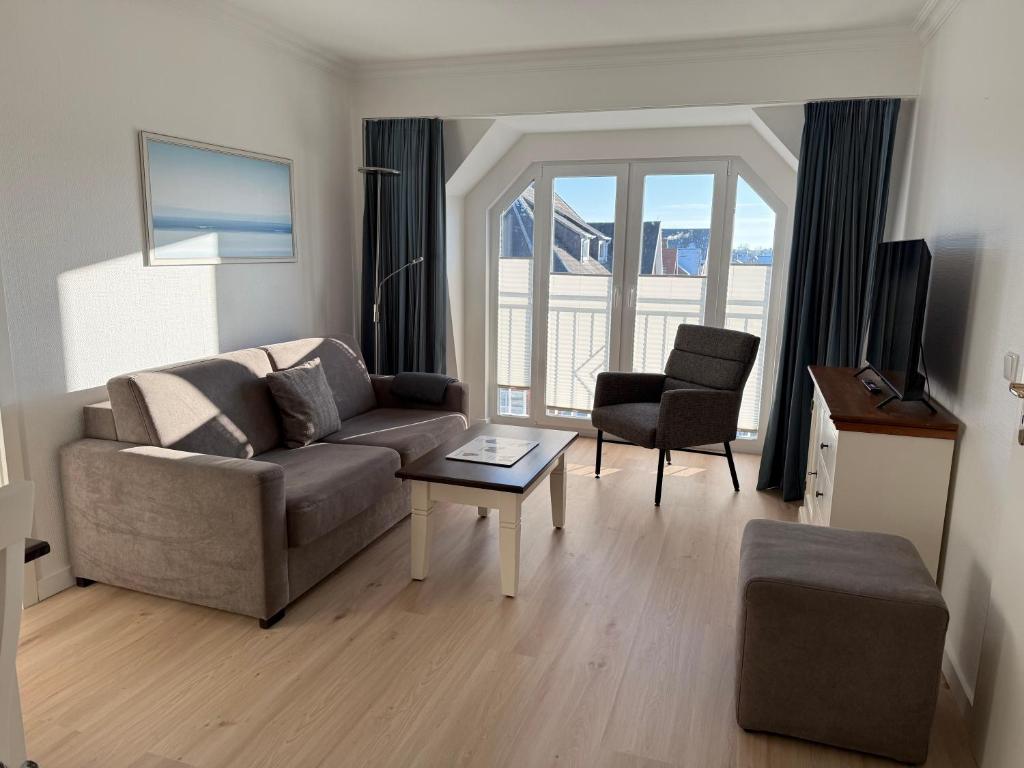 a living room with a couch and a table at Appartementhaus Hoppe in Sylt