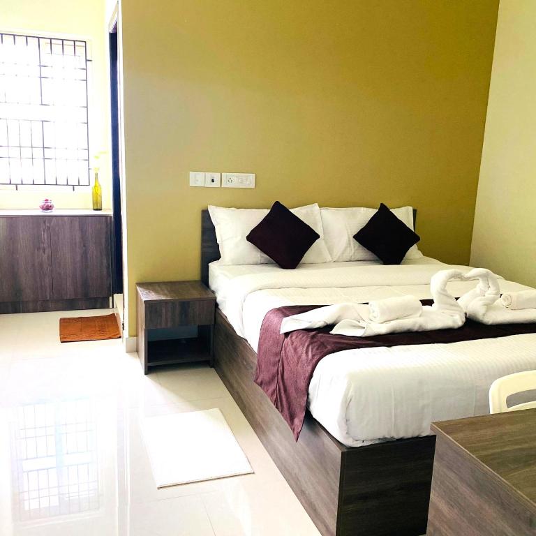 a bedroom with two beds and a window at Hotel I Live Inn in Chennai