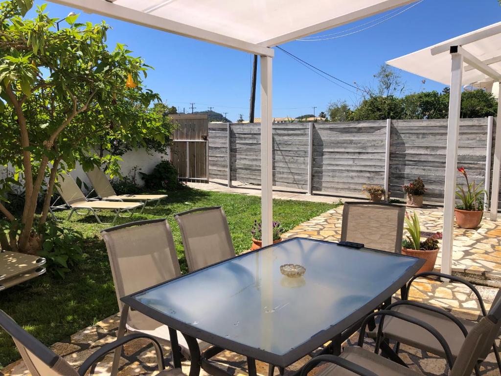 a patio with a blue table and chairs at Sidari High Street Apartment in Sidari