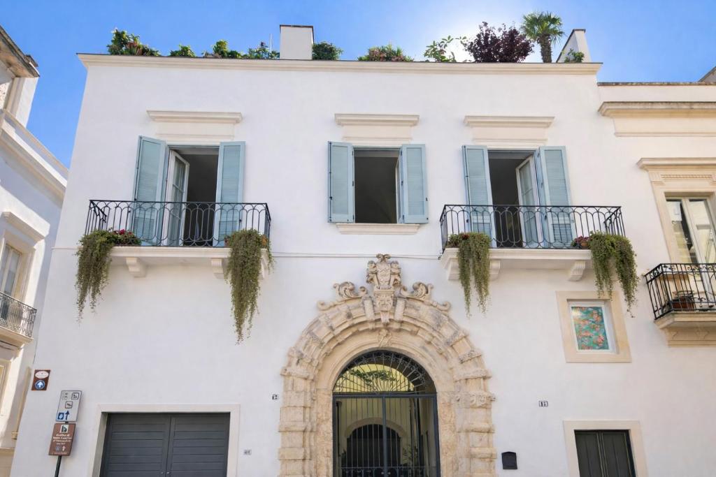 a white building with an archway and windows at Palazzo Luceri in Galatina