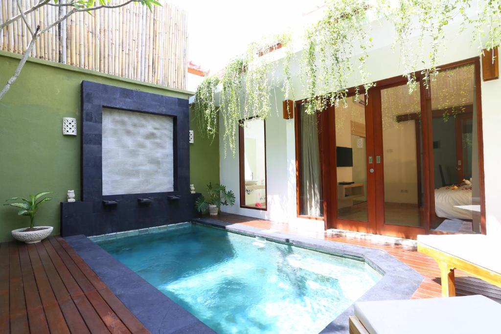 a swimming pool in the middle of a house at Jas Green Villas and Spa in Seminyak