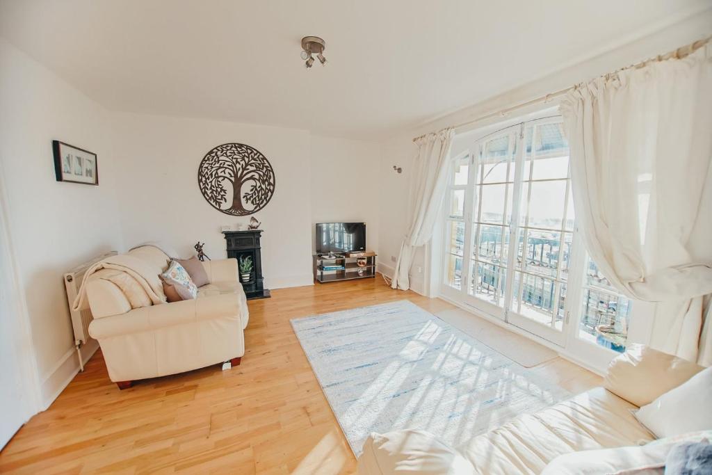 a living room with a couch and a large window at The Pelham Penthouse in Hastings