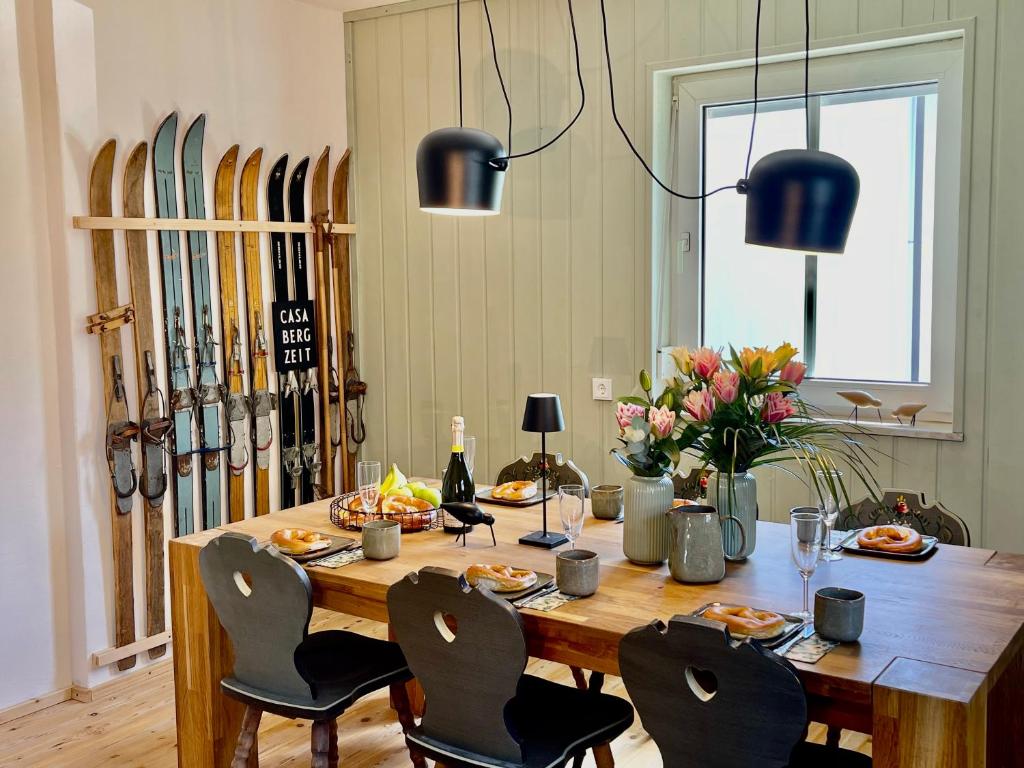 a dining room with a table with chairs and skis at Ferienhaus Ferienwohnung CasaBergZeit mit Königscard im Allgäu, Pfronten, Füssen in Pfronten