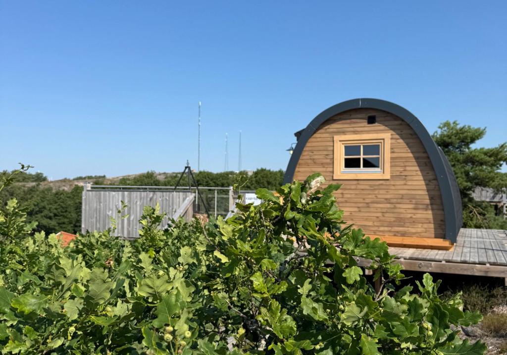 a circular house with a round window on a roof at GrebbestadFjorden glampingpoddar in Grebbestad