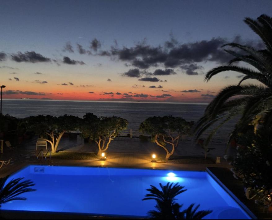 a swimming pool with a view of the ocean at sunset at Sunset Villa Favazzina- Piscina e vista sul Mare in Favazzina