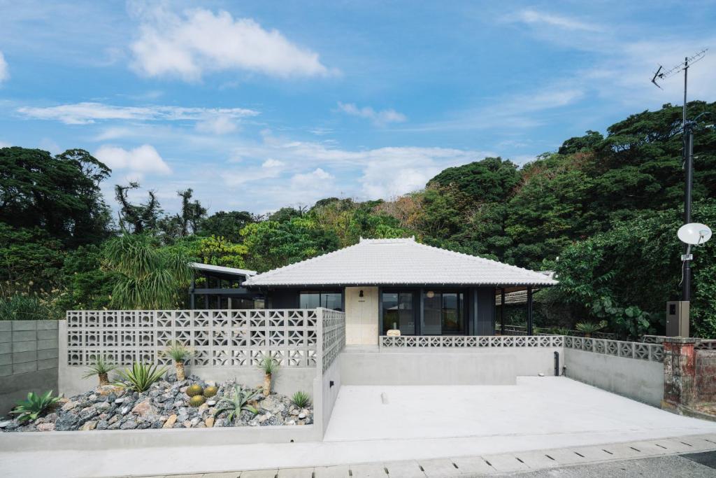 a building with a fence in front of it at TaaCH Okinawa in Nago