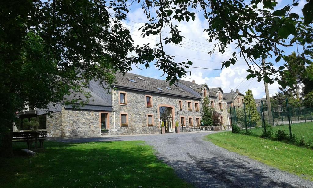 a large stone house with a driveway in front of it at Gite 2 de Renuamont in Sainte-Ode