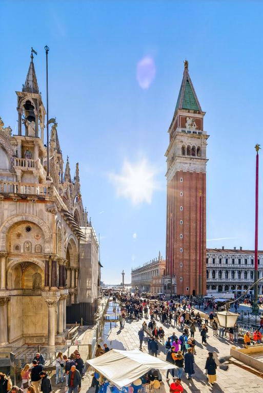 a crowd of people standing in front of a clock tower at Bellevue Luxury Rooms - San Marco Luxury in Venice