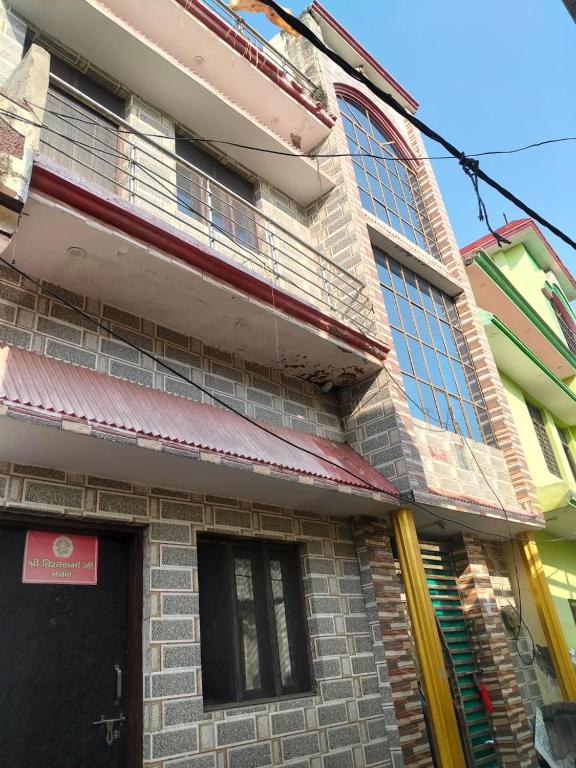 a building with a black door and windows at Vishawkarma Homestay in Gajraula