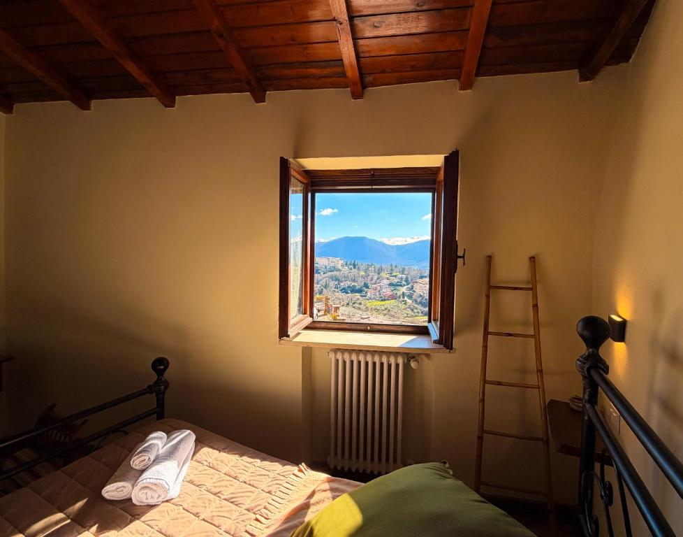 a bedroom with a bed and a window with a view at IL COLLE Holiday Home - FIUGGI - Charming independent home in the historic center, near the Thermal Baths & Wellness Retreats in Fiuggi