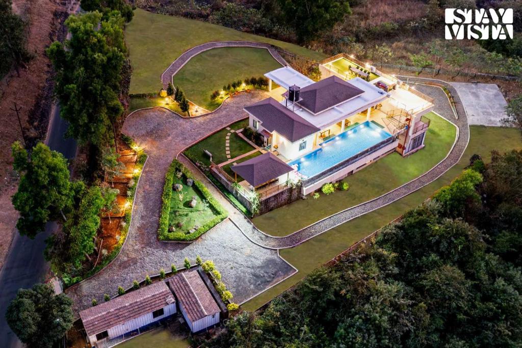 an aerial view of a house with a swimming pool at StayVista at Beyond Infinity with Hill View, BBQ in Lonavala