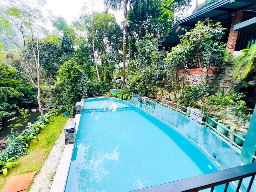 an empty swimming pool in a yard with trees at Niwana Resort in Ratnapura
