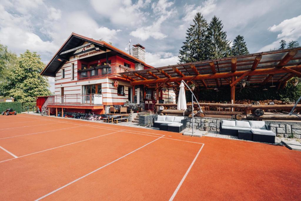 a house with a tennis court in front of it at Penzion Rak Wellness in Černá v Pošumaví
