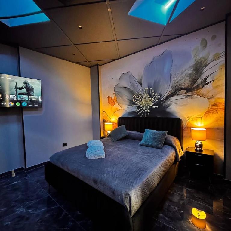 ein Schlafzimmer mit einem Bett und einem Blumenbild an der Wand in der Unterkunft Opera 235 in Isernia