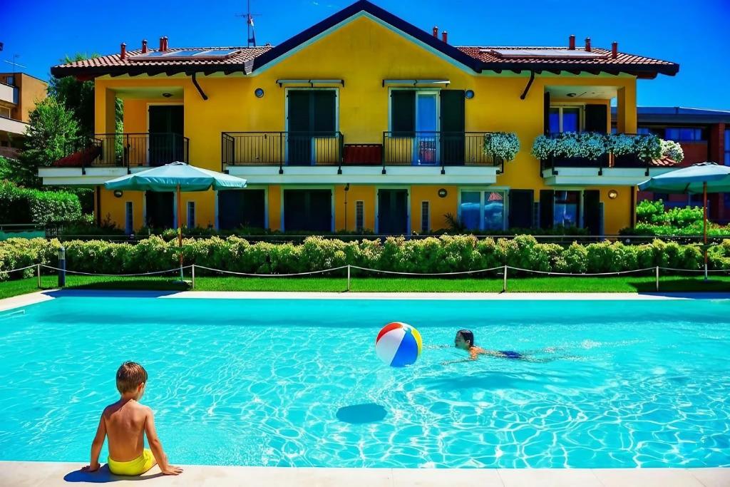 two children playing in a swimming pool with a beach ball at Bellagio Wave Apartment in Bellagio