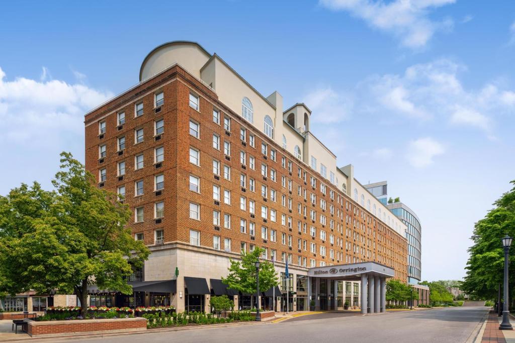 a large red brick building on a street at Hilton Orrington/Evanston in Evanston