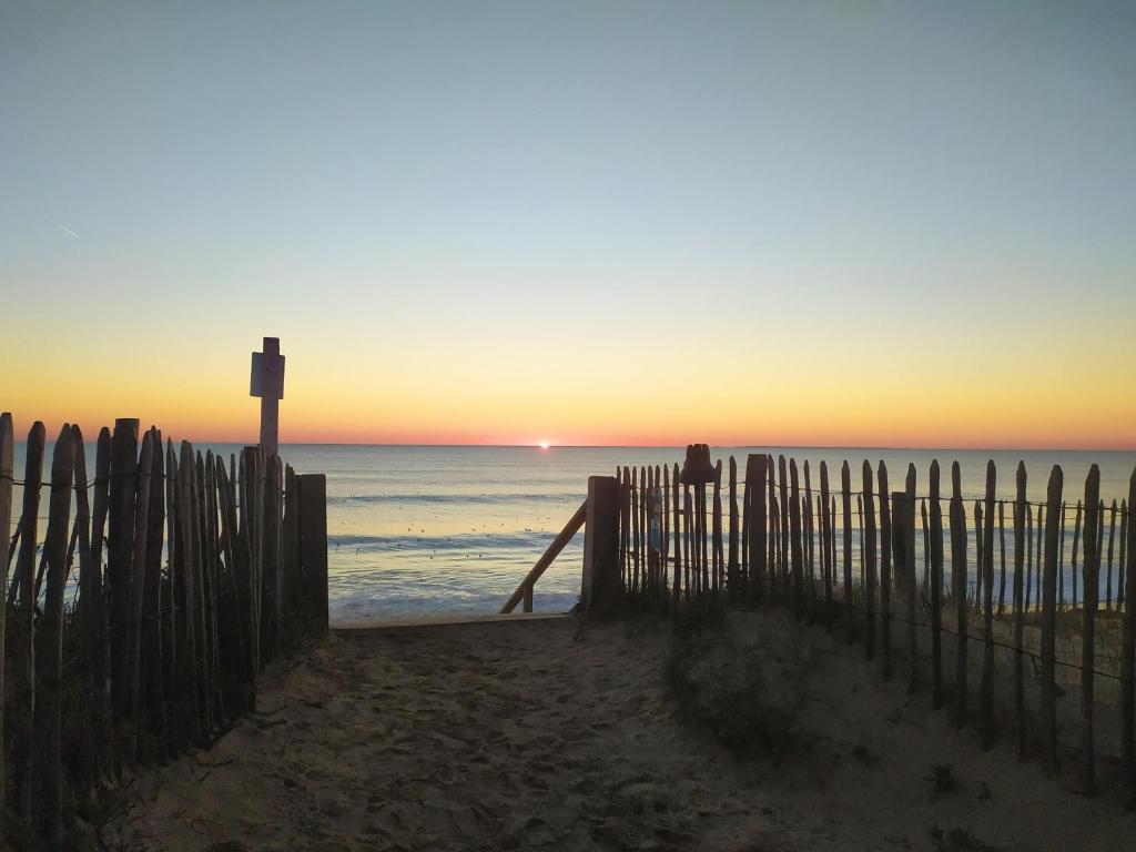 a person sitting on the beach watching the sunset at RIEZ Entre Mer et Dunes in Saint-Hilaire-de-Riez