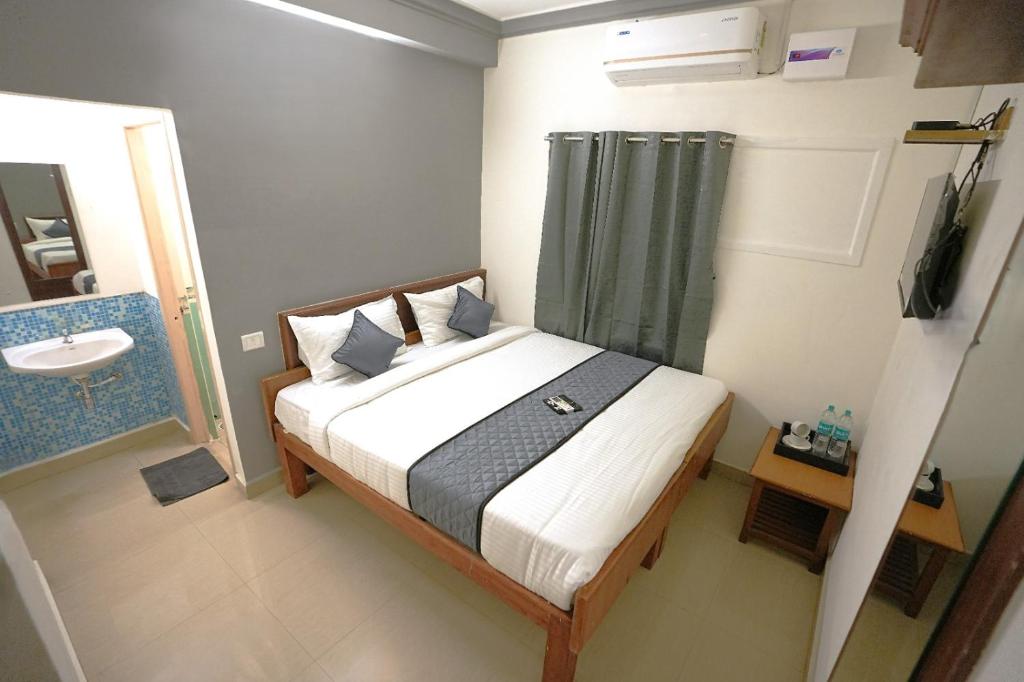 a bedroom with a bed and a bathroom with a sink at Blessings select DLF in Chennai