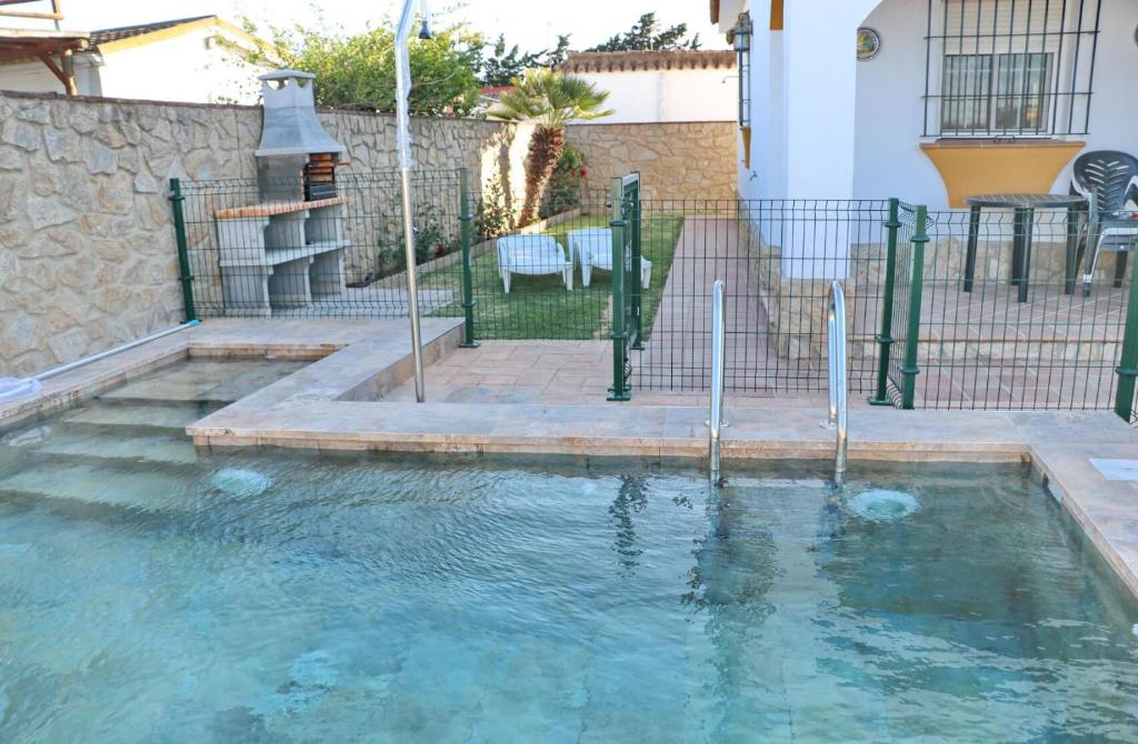 a pool of water with a fountain in a yard at Chalet El Palmar in El Palmar