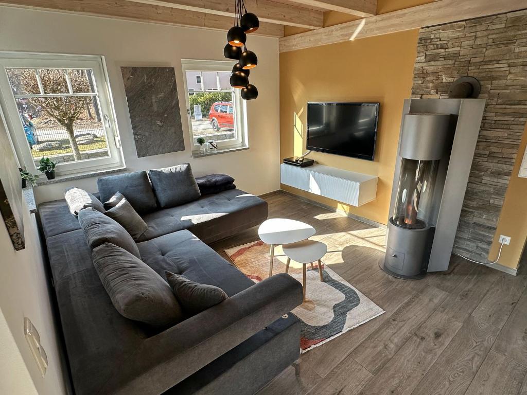 a living room with a couch and a tv at Brückelsee-Chalet in Wackersdorf