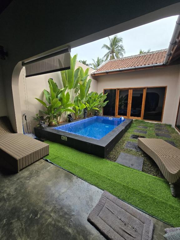a swimming pool in the backyard of a house at Villa Lamorna in Krui