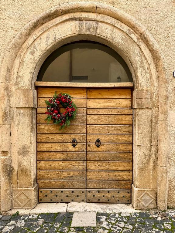 a wooden garage door with a wreath on it at Rifugio del vicolo in Lucoli Alto