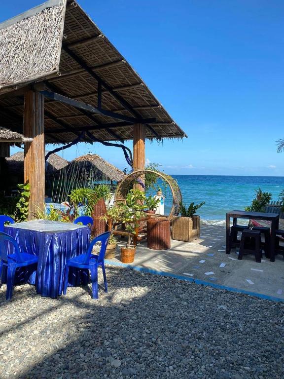 a table and chairs under a pavilion on the beach at Satosa Beach Resort in San Joaquin