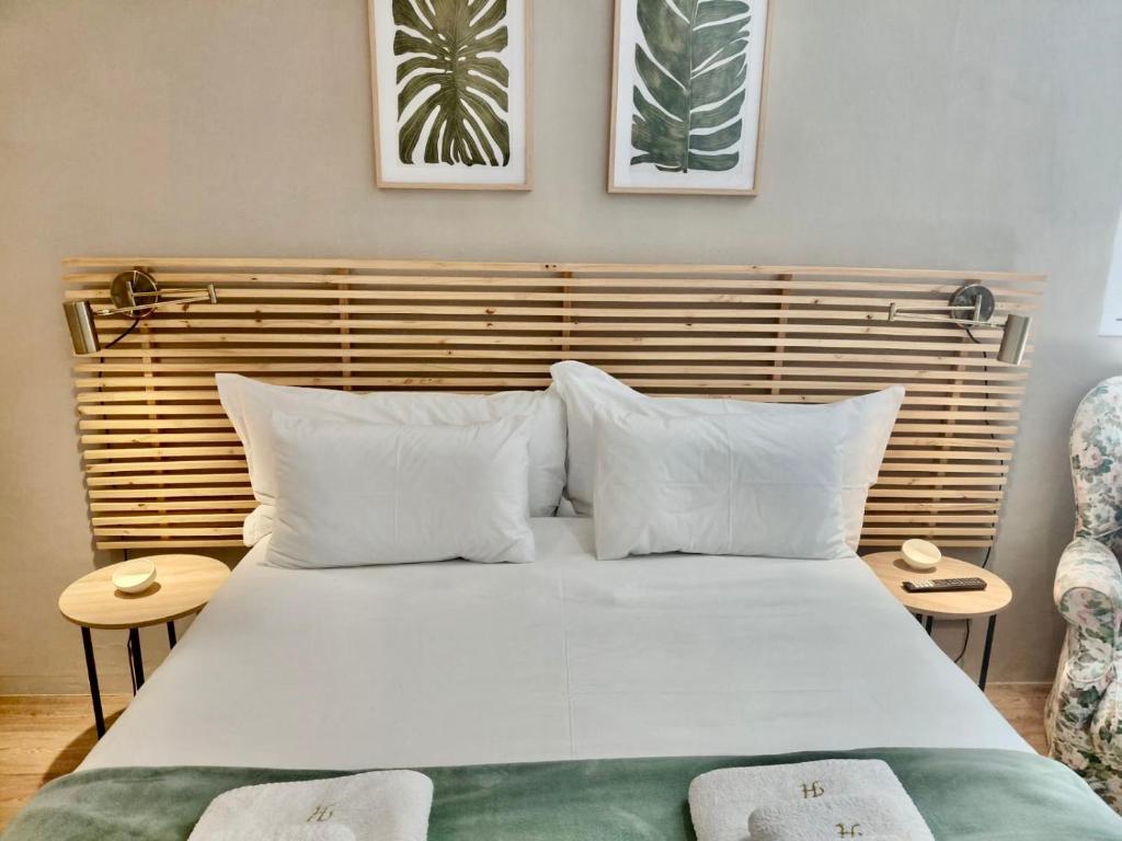 a bedroom with a large white bed with a wooden headboard at The Botanic High Gold in Paarl