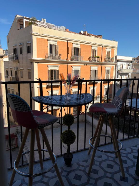a table and two chairs on a balcony at Elisir house in Palermo