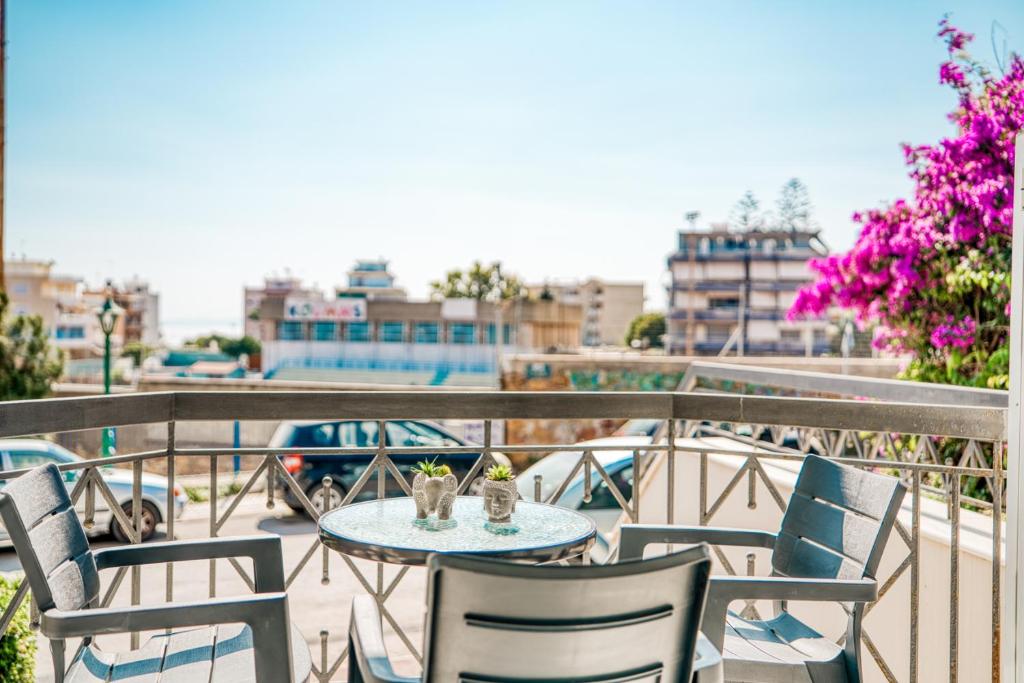 a table and chairs on a balcony with a view at Modern City Studio with Balcony Columbus Apartment in Chios