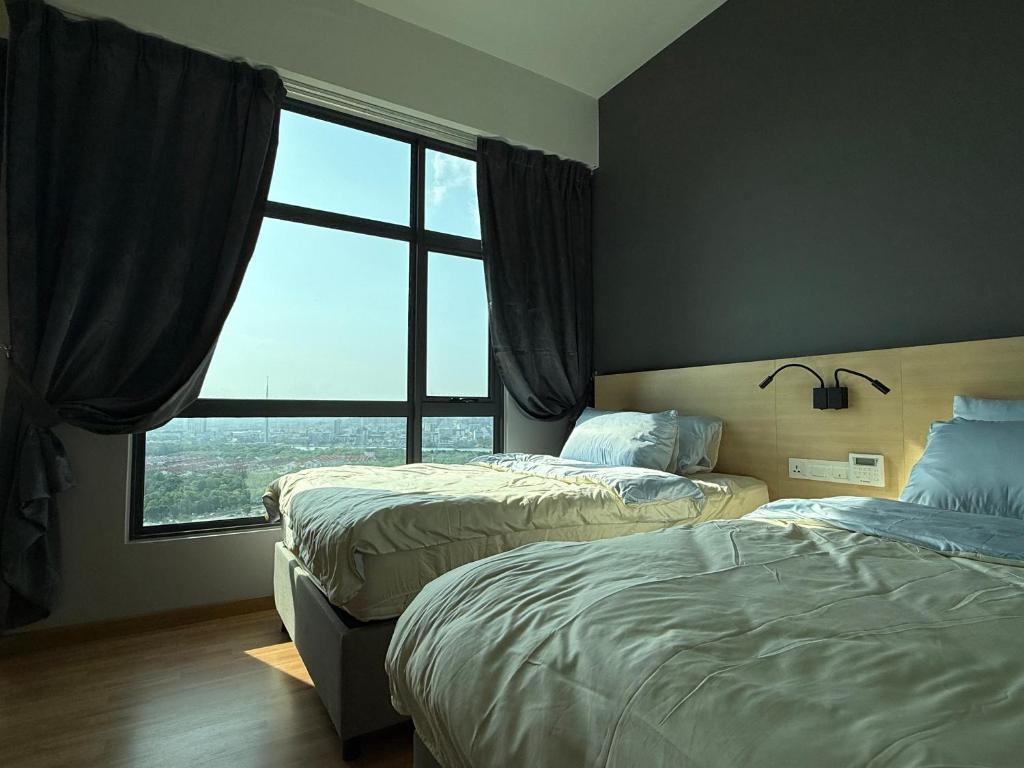 a bedroom with two beds and a large window at Swiss Cozy Studio Kuantan City View Imperium Residence in Kuantan