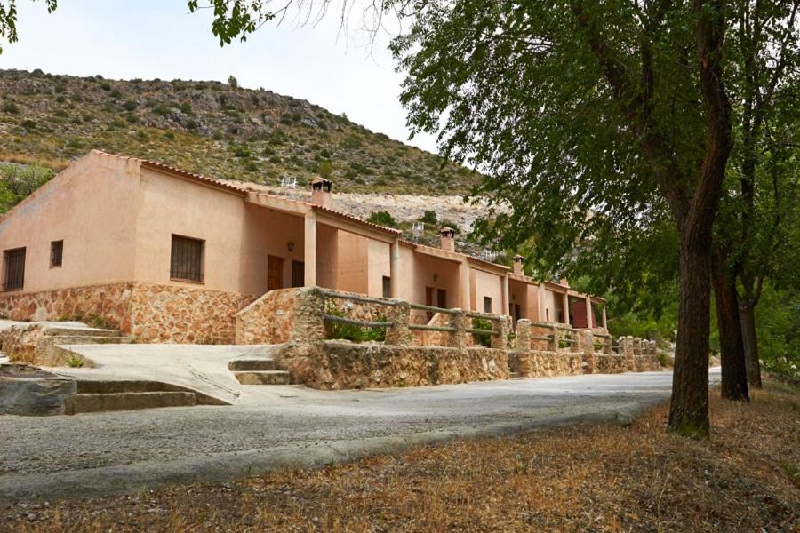 a building with a hill in the background at Complejo Rural las Fuentes de Letur in Letur
