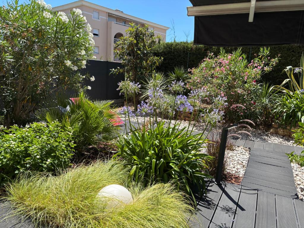 a garden with flowers and plants in front of a building at Les Enganes in Fréjus