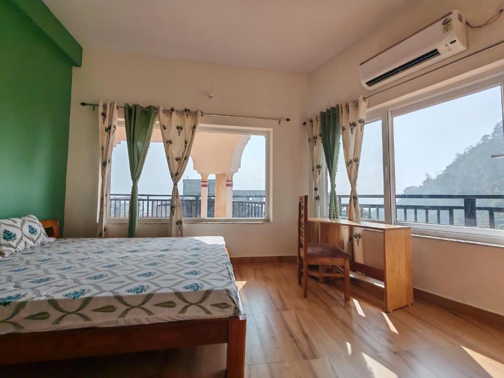 a bedroom with a bed and a large window at Om Homestay in Rishīkesh