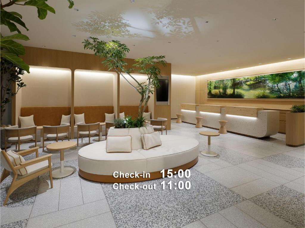 a lobby with a waiting area with chairs and tables at Mitsui Garden Hotel Sapporo in Sapporo