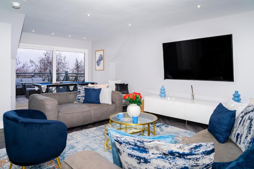 a living room with a couch and a tv at The Gleneagles Hideaway - Luxury 3 Bed With Complimentary Access to Onsite Leisure Facilities in Gleneagles Station