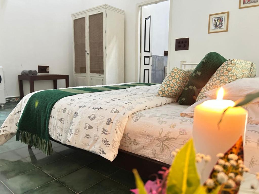 a living room with a bed and a candle at Crepe Ginger Home Stays in Hariharpur