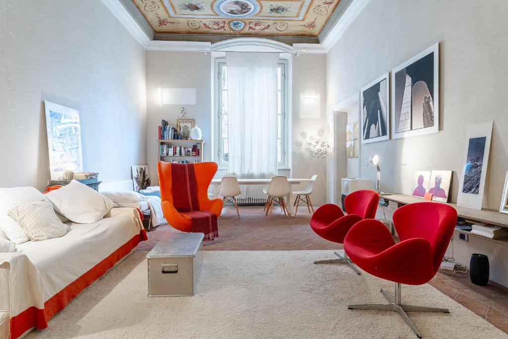 a living room with red chairs and a couch at L'affresco in Via Guinigi in Lucca