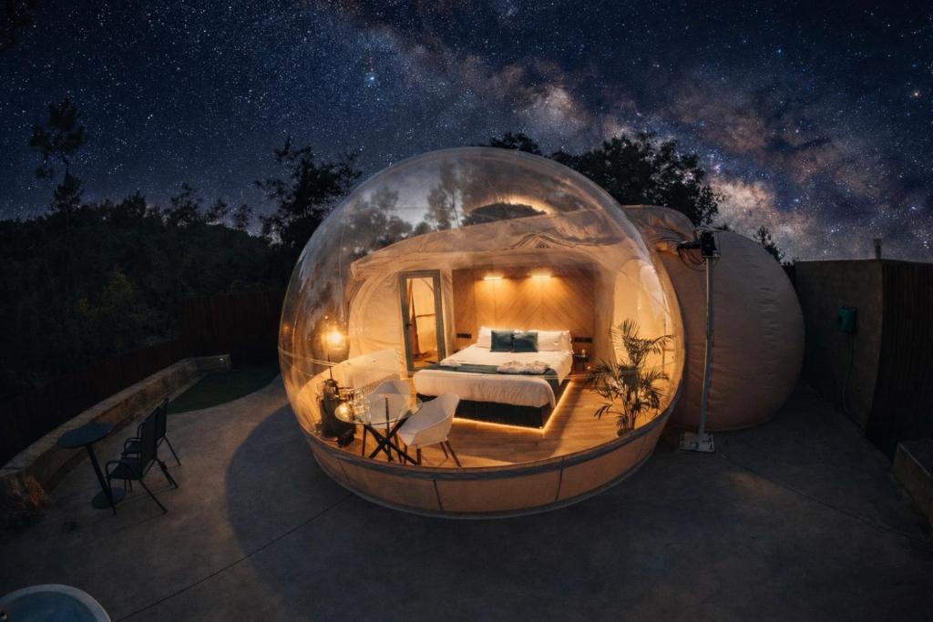 a bedroom in a dome shaped house at night at Glamping Balú in Monesterio