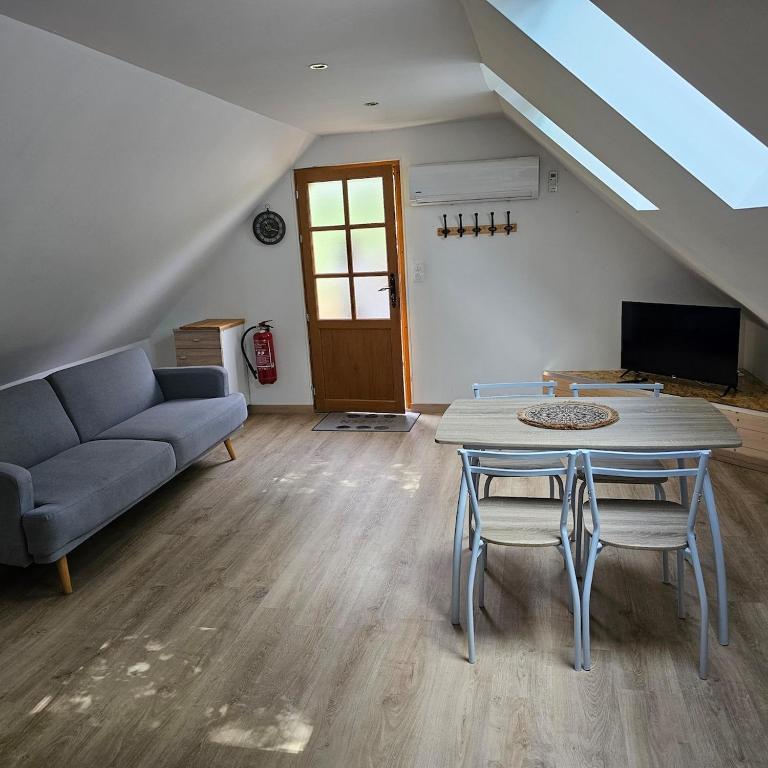 a living room with a table and a couch at Hébergement Cosy in Bourg-et-Comin
