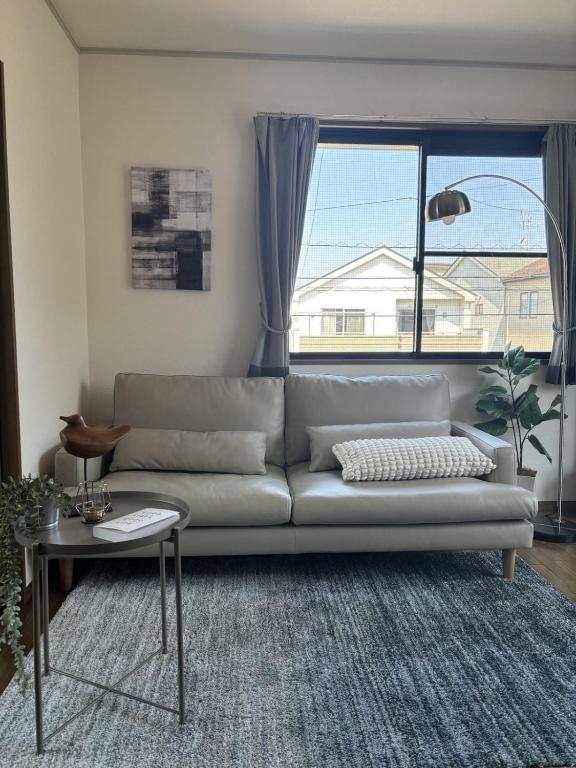 a living room with a couch and a large window at Matsudo in Matsudo