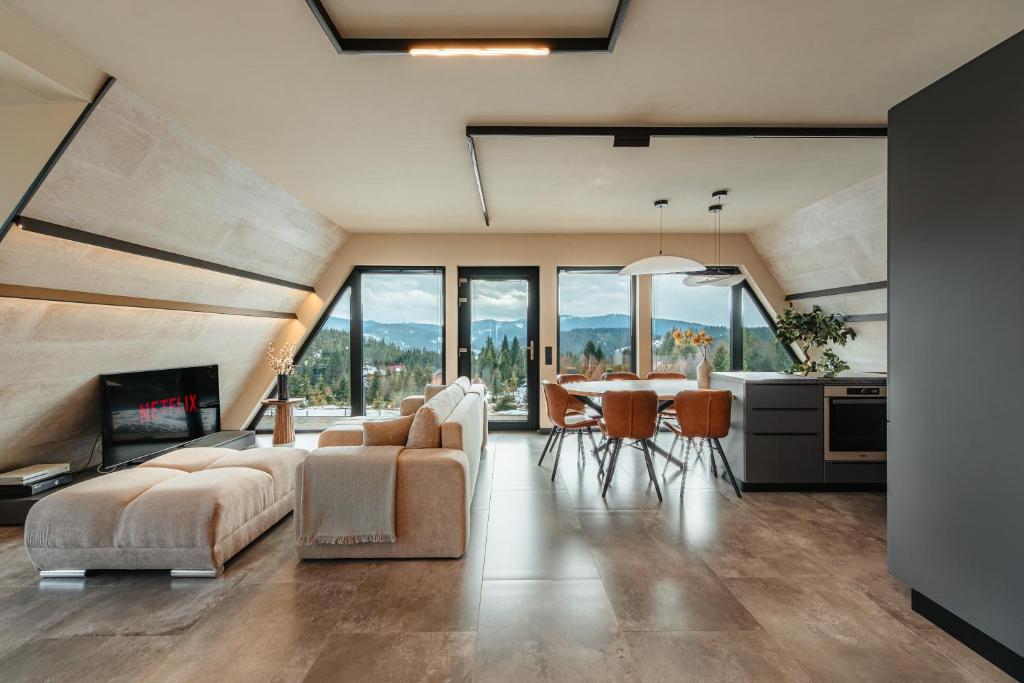 ein Wohnzimmer mit Sofa und einem Tisch mit Stühlen in der Unterkunft Sunset A Frames in Bălceşti