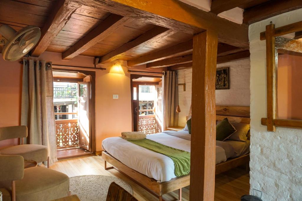 a bedroom with a bed and a balcony at Bandipur Bazar Ghar in Bandipur