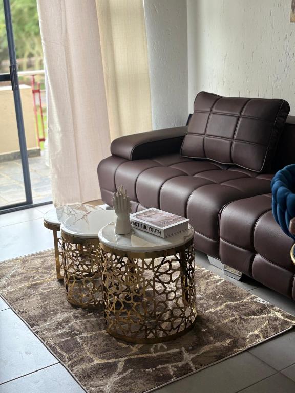 a living room with a couch and two tables at The golf estate gateway in Roodepoort