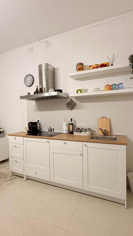 a kitchen with white cabinets and a counter top at Lucy Home in Pisticci