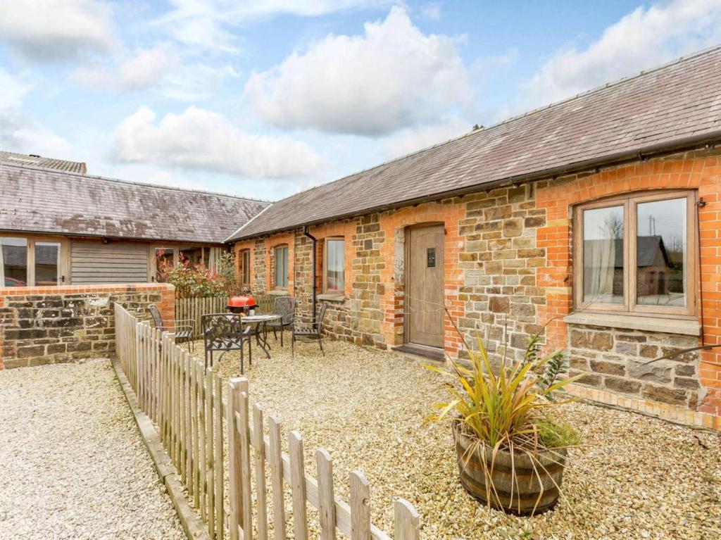 a brick house with a fence and a patio at 2 Bed in Umberleigh oc-09091 in Umberleigh Bridge