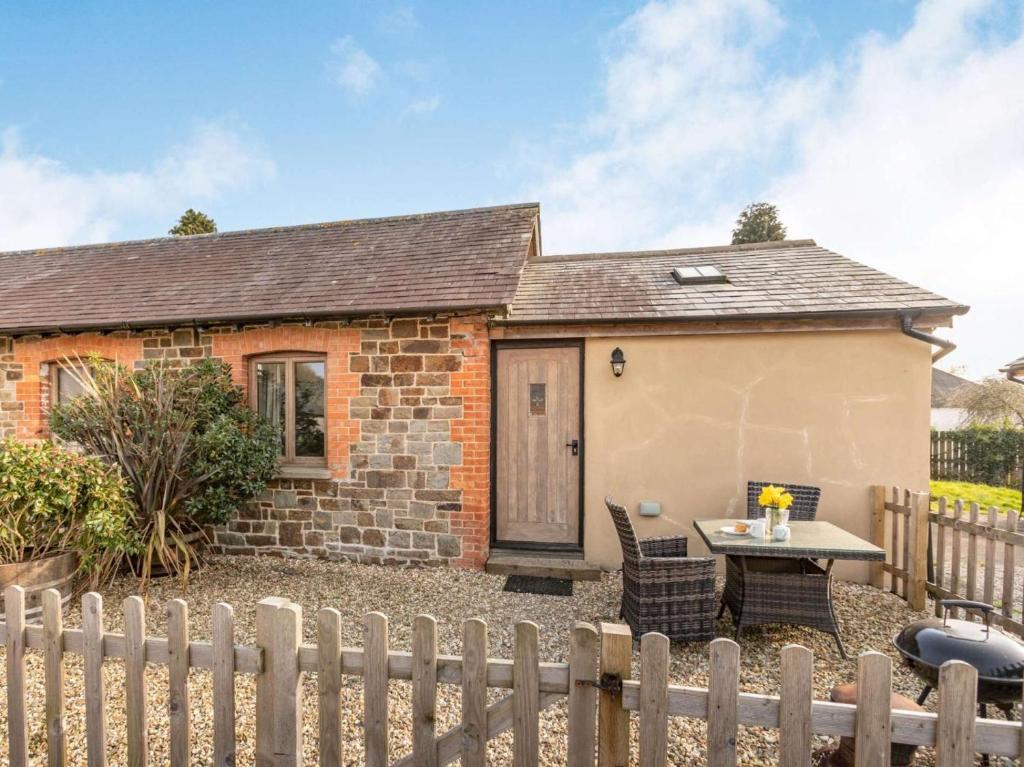 a cottage with a table and chairs in front of it at 1 Bed in Umberleigh oc-09090 in Umberleigh Bridge